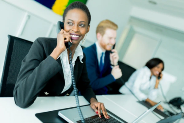 Colleagues conducting client calls by phone in an open office