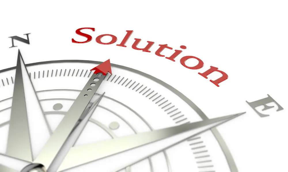 A compass needle pointing at the word Solution